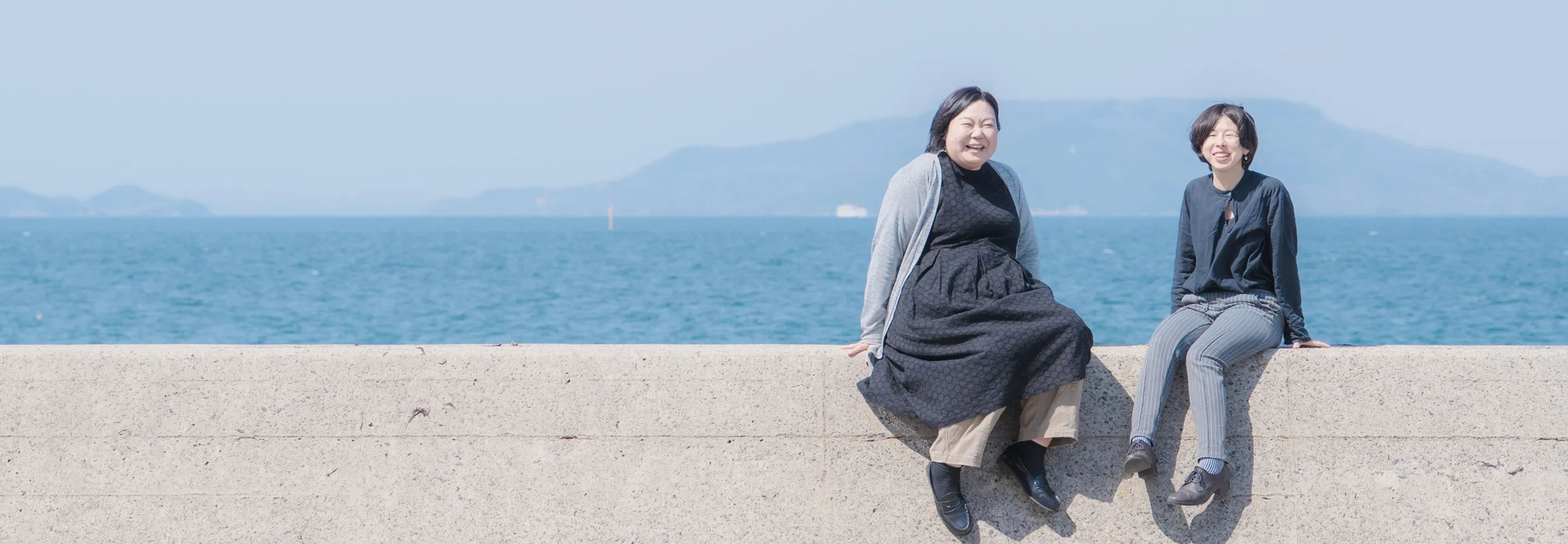 代表二人が海辺で座っている写真