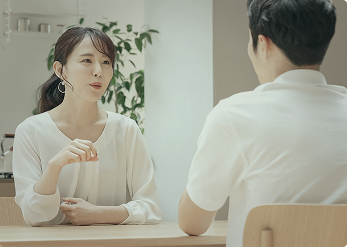 テーブルを挟んで向かい合い、相談をしている男女の様子