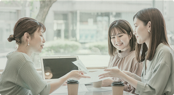 書類を見ながら打ち合わせを行う女性3人の様子