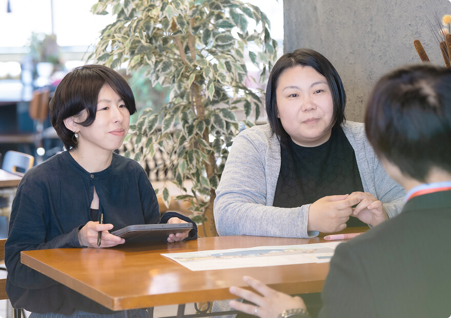 テーブルを囲み資料を見ながら住まいの相談をしている打ち合わせ風景