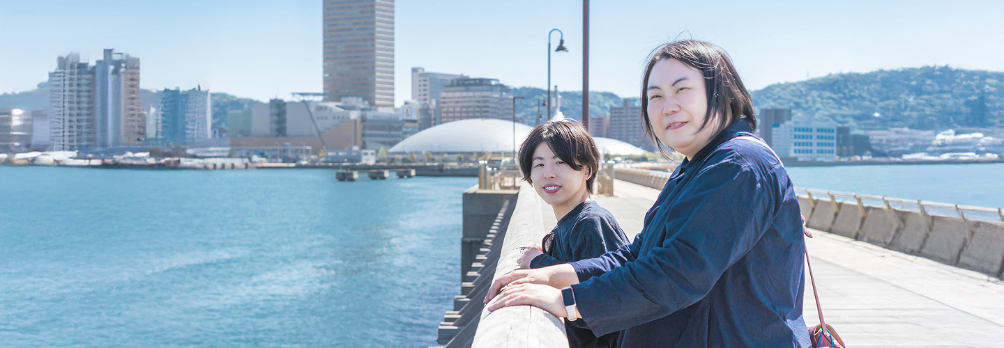 代表二人が海辺で笑顔の写真